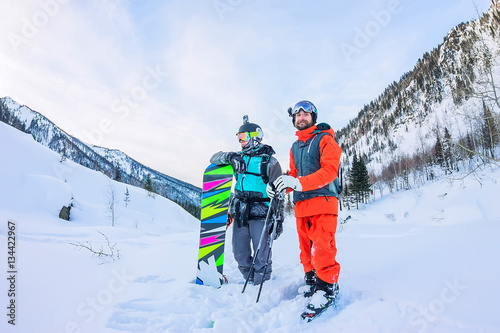 Freeriders male skiers and snowboarders are in the mountains in