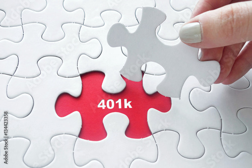 Hand placing  jigsaw puzzle with 401k text