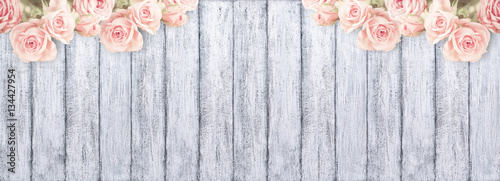 Roses on background of shabby wooden planks with place for text.