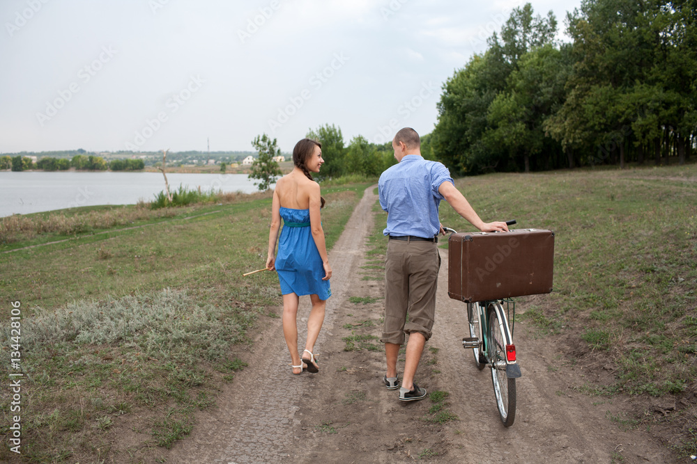 Boy and girl walking with a bicycle Boy and girl walking with a bicycle
