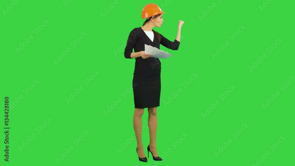 Angry female chief engineer with documents arguing with workers on a Green Screen, Chroma Key Angry female chief engineer with documents arguing with workers on a Green Screen, Chroma Key