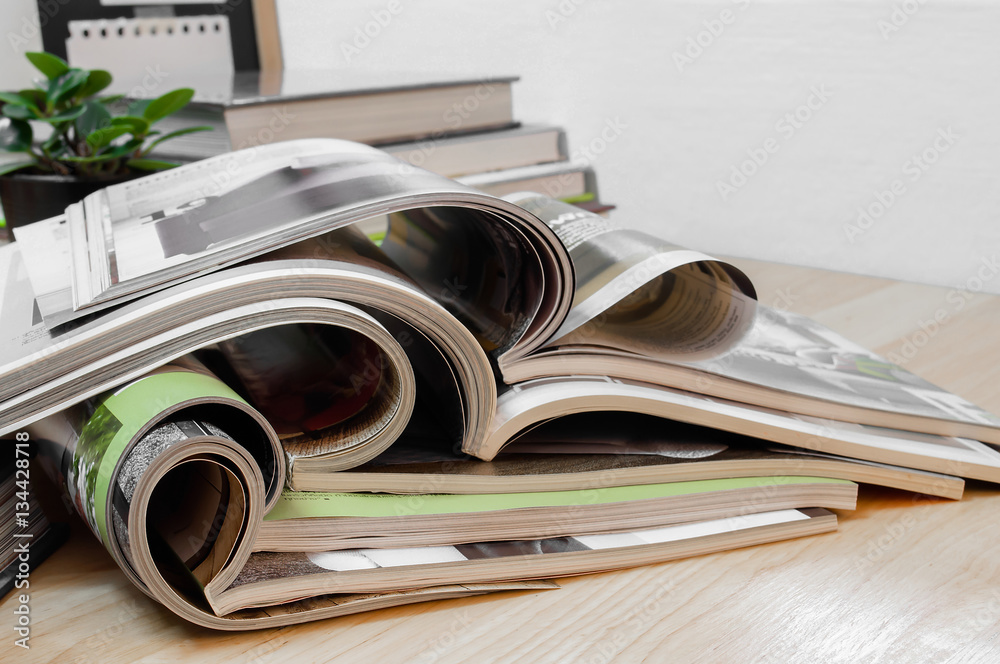 Closeup Stack of colorful magazines on wooden table with blackboard. Closeup Stack of colorful magazines on wooden table with blackboard.