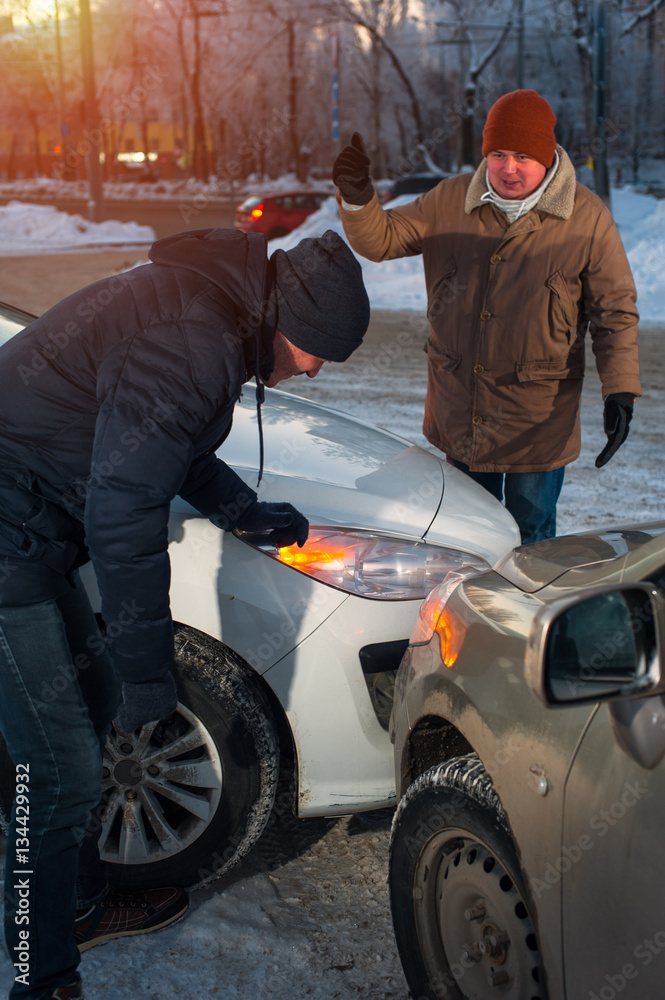 Two drivers arguing after car crash on city street