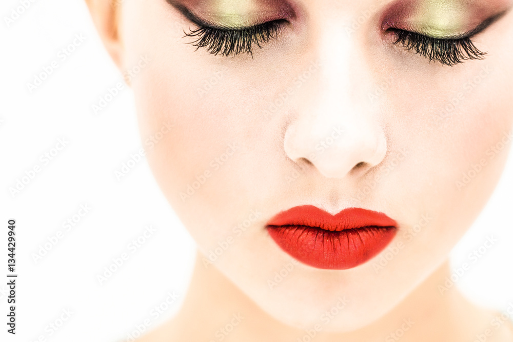 Close-up. Portrait of a woman with red lips and closed eyes on a light background