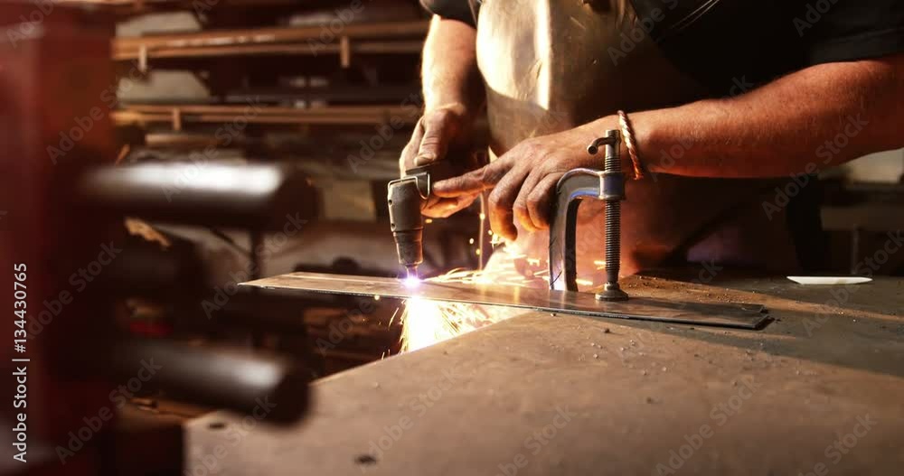 Mid-section of welder using welding torch in workshop 4k Mid-section of welder using welding torch in workshop 4k