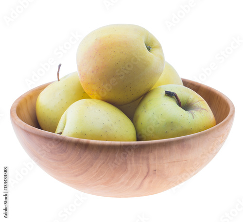 big ripe juicy yellow golden apples in wooden bowl isolated on white background