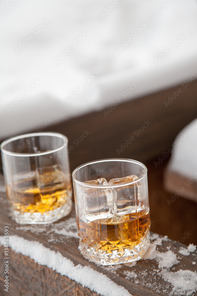 Fototapeta premium Two whiskey glasses in the snow on a winter background.