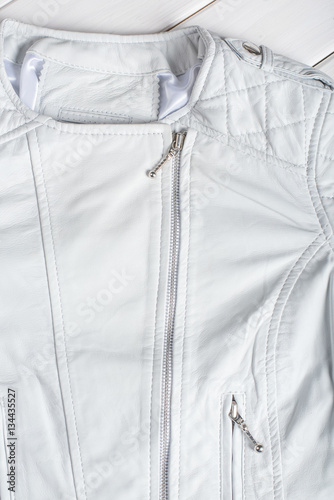 White leather jacket on white background. Leather jacket macro details. Jacket zippers and pockets © sergmam
