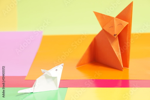 Paper origami fox and mouse are isolated on a colorful background © romanklevets