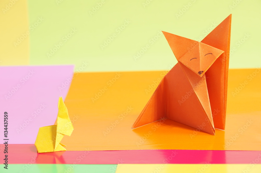 Paper origami rabbit and fox are isolated on a colorful background Paper origami rabbit and fox are isolated on a colorful background