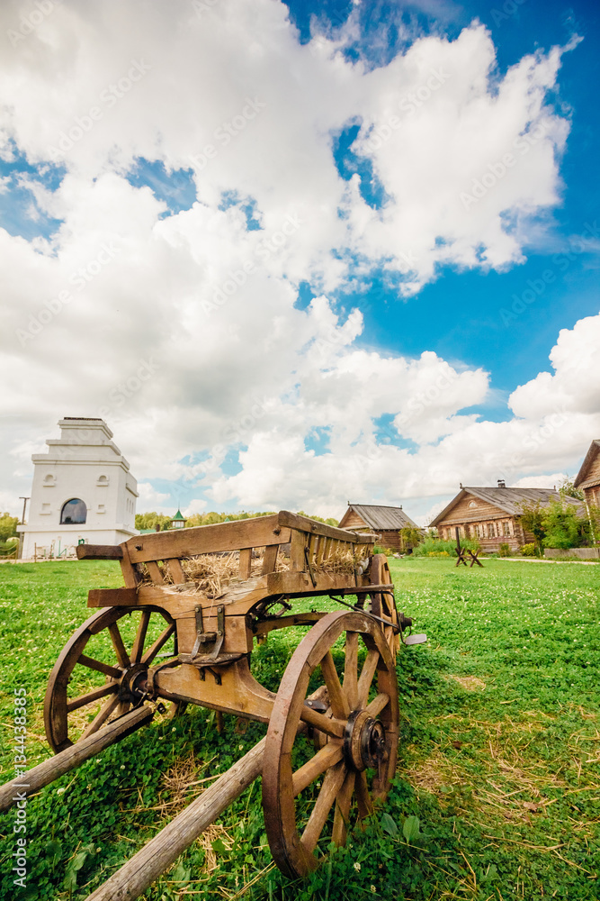 Old vintage wagon on the background of sky and village