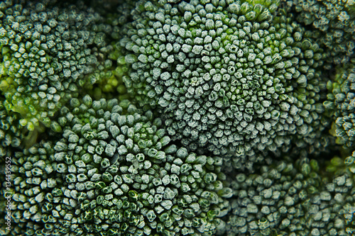 Fresh frozen green broccoli with hoarfrost closeup as background. Healthy vitamin food.