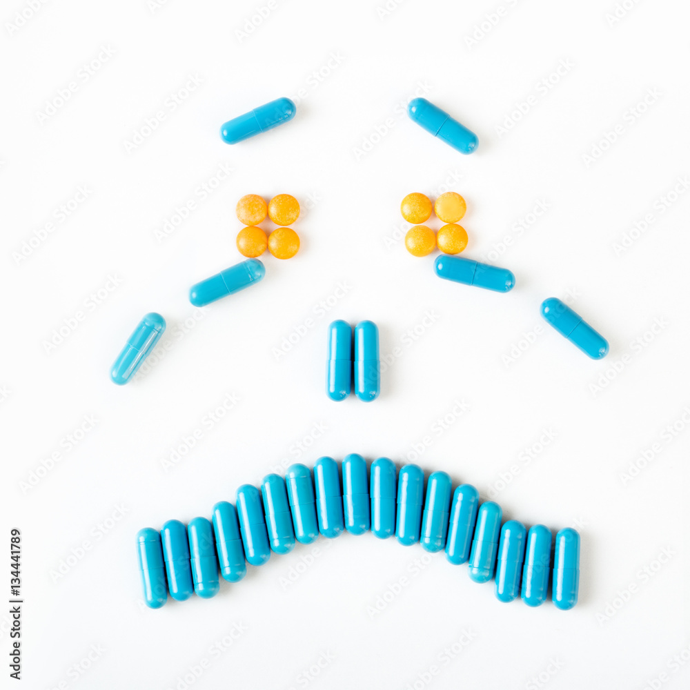 Sad and crying smile made from many pills capsules. wellness concept Sad and crying smile made from many pills capsules. wellness concept
