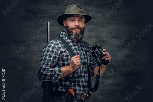 Fotografie A hunter holds a rifle.