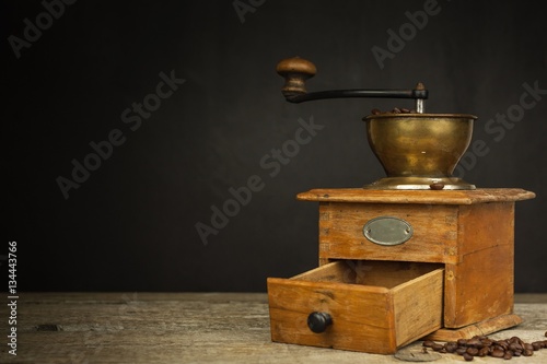Old wooden coffee grinder on a wooden table. Homework hot coffee. Advertising for the sale of coffee.