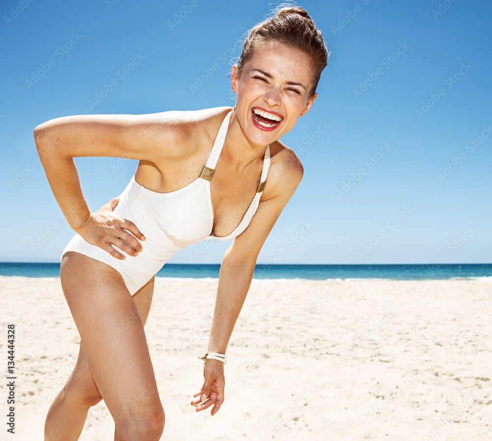 Portrait of happy woman in white swimsuit at sandy beach Portrait of happy woman in white swimsuit at sandy beach
