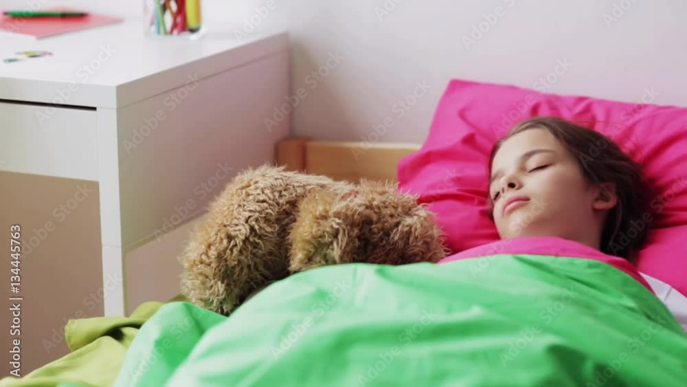 little girl with teddy bear sleeping at home