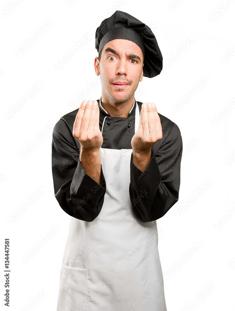 Puzzled young chef posing Puzzled young chef posing
