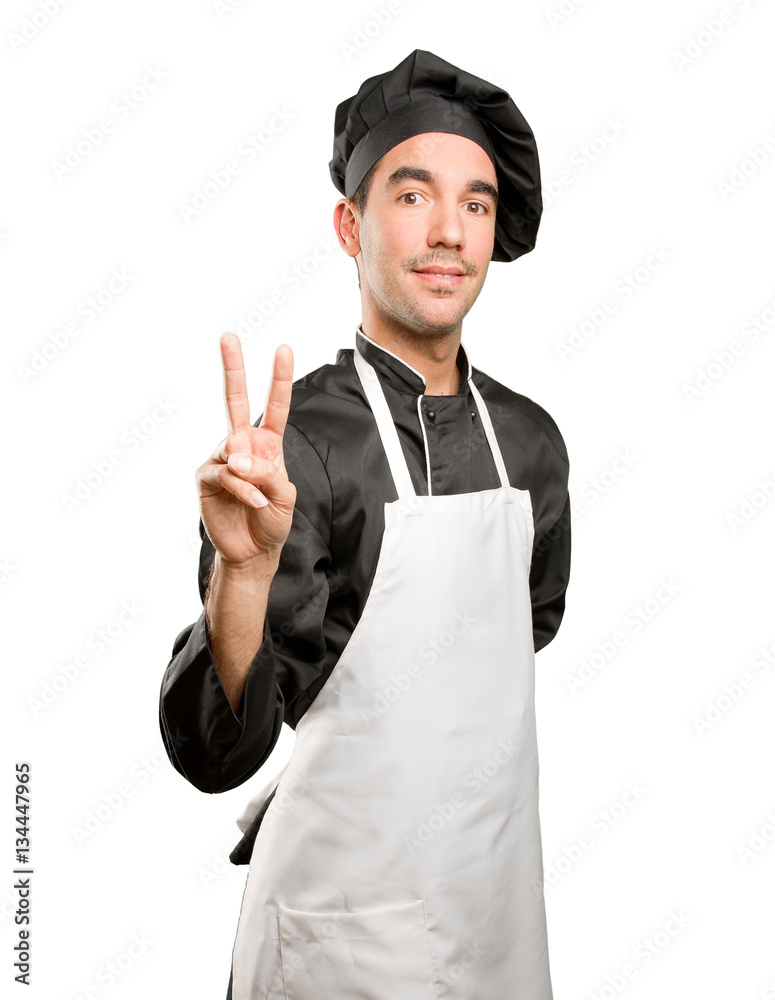 Confident young chef with a victory gesture Confident young chef with a victory gesture