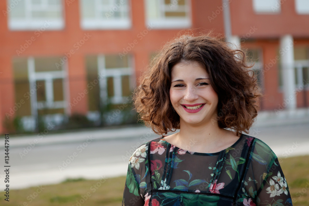 Fototapeta premium Happy curvy girl with curly hair in the street