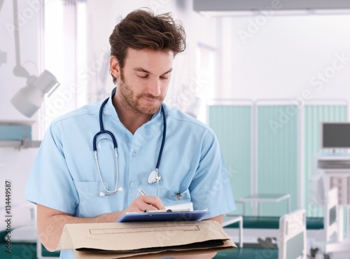 Doctor filling out patient record in hospital