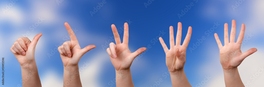 Mit Fingern zählen vor einem Wolkenhintergrund Mit Fingern zählen vor einem Wolkenhintergrund