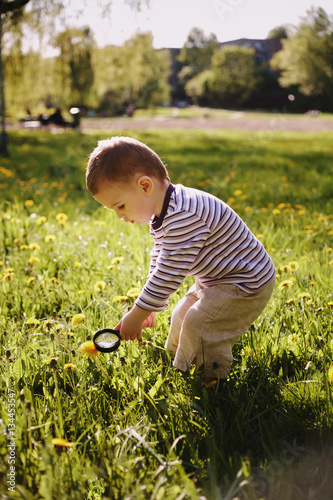 Принти на полотні boy child magnifying glass exploring meadow