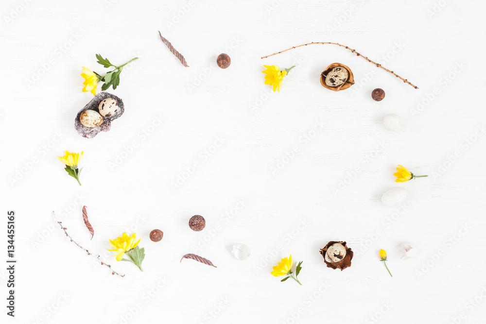 Easter frame made of quail eggs and yellow flowers. Easter concept. Flat lay, top view