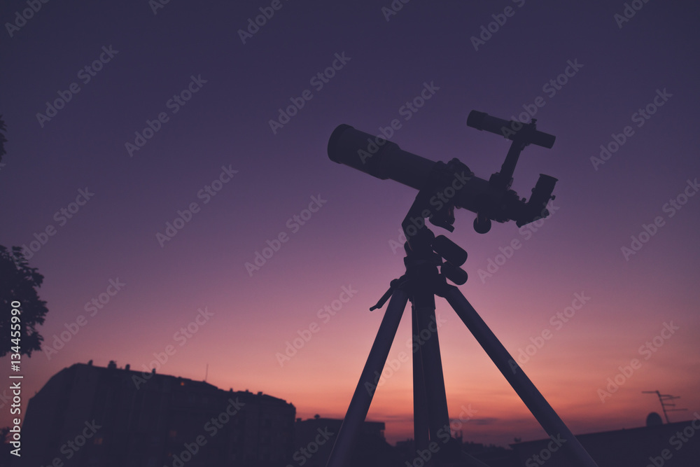 Silhouette of a telescope on a morning / evening sky.