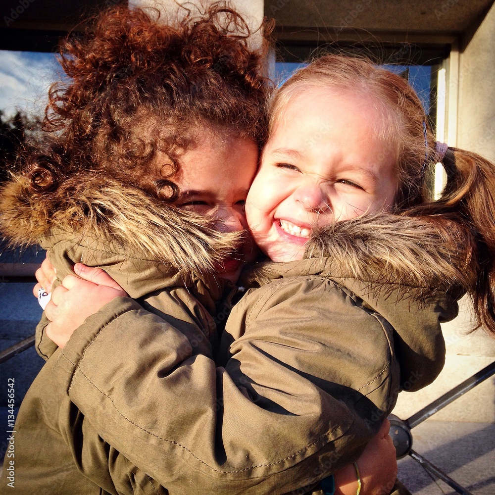 Doa niñas felices abrazadas con mucha fuerza - obrazy, fototapety, plakaty 