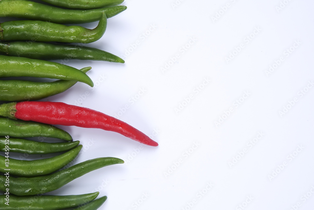 Red chili on green chillies on white background concept : different, win, better Red chili on green chillies on white background concept : different, win, better