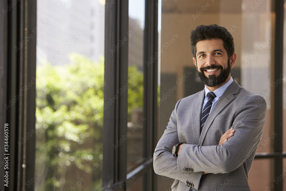 Smiling Hispanic businessman with arms crossed, to camera Smiling Hispanic businessman with arms crossed, to camera