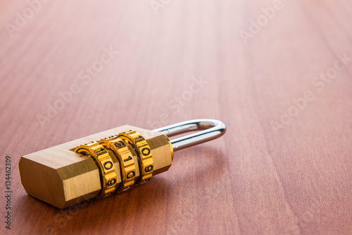 Lock with the code set on the wooden background.