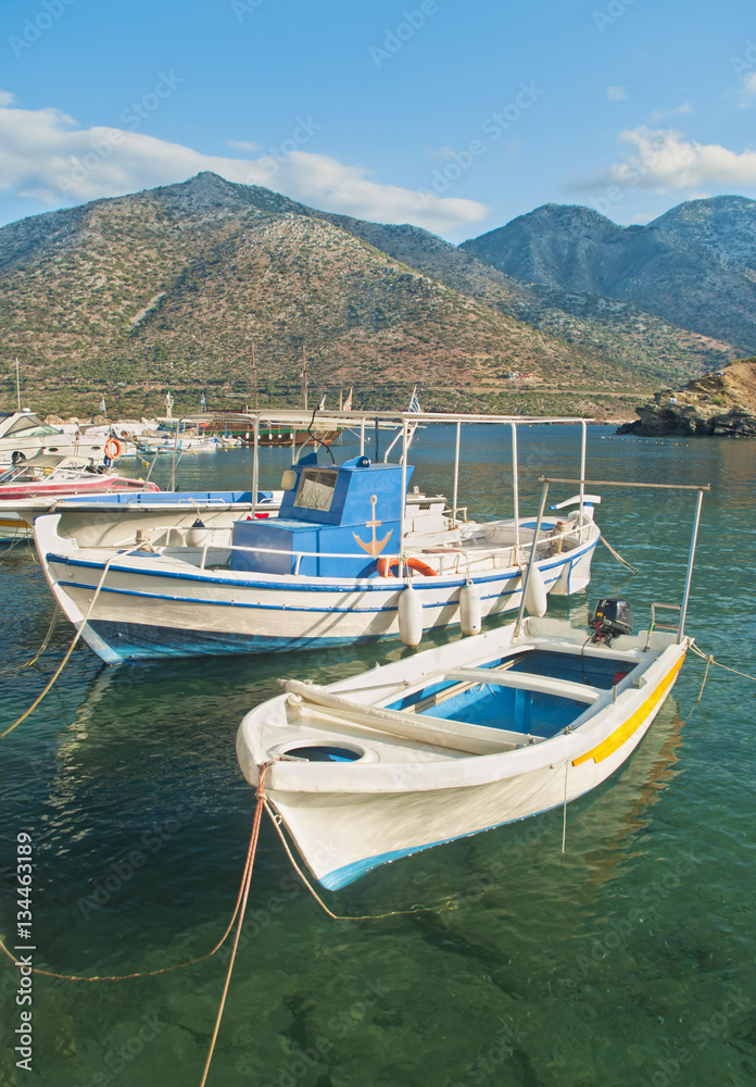 white fishing boats in small mountainous harbour