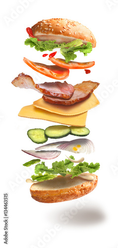 hamburger with flying ingredients on white background