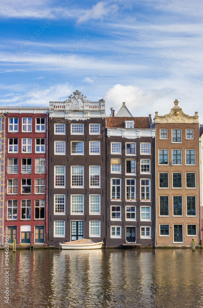 Colorful houses and boat at the Damrak in Amsterdam