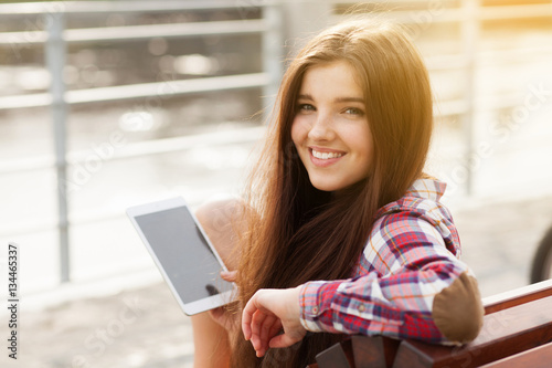 Face portrait of young woman using a tablet pc