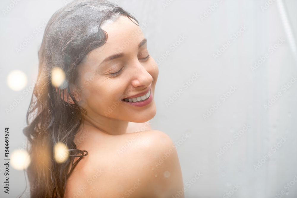 Naklejka premium Sensual portrait of young woman taking a shower. Body and skin hygiene