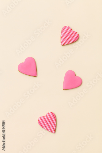 Top view on three little gingerbread cookies in shape of hearts on light yellow background. Flay layout. Love, Valentines's day concept