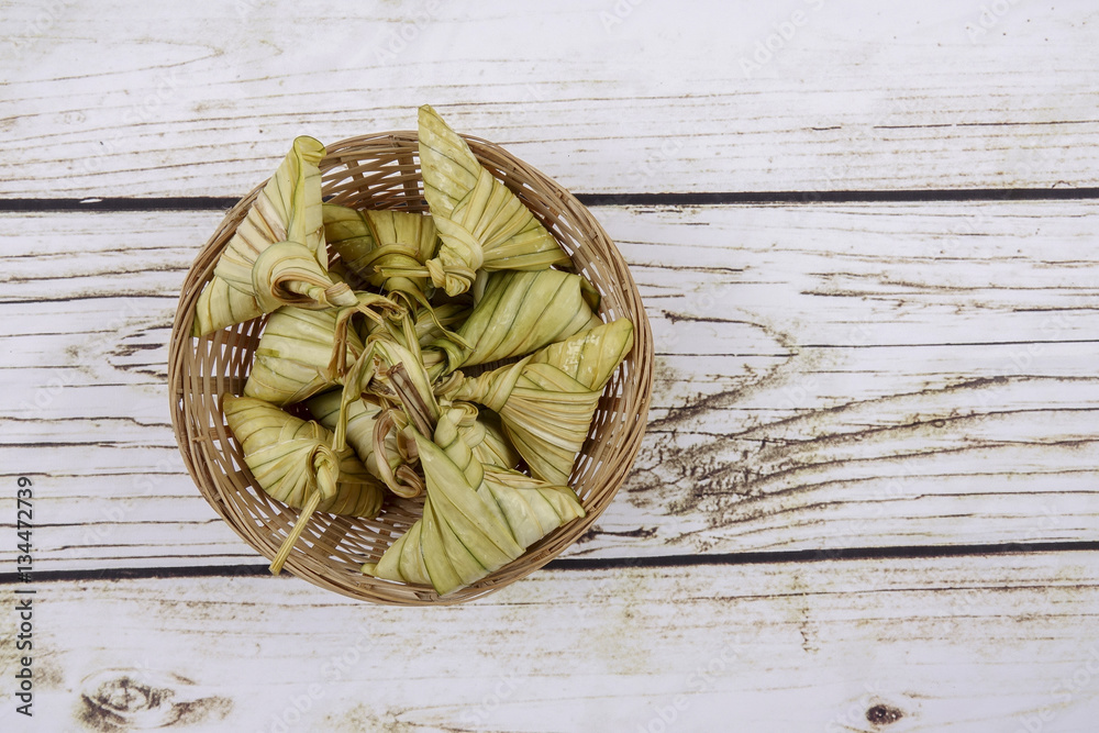 Ketupat (Rice Dumpling) On wooden Background. Ketupat is a natural rice casing made from young coconut leaves for cooking rice during eid Mubarak