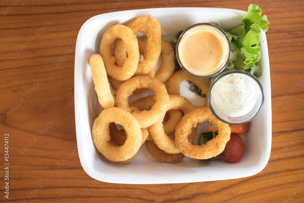 Fried onion rings in batter with sauce