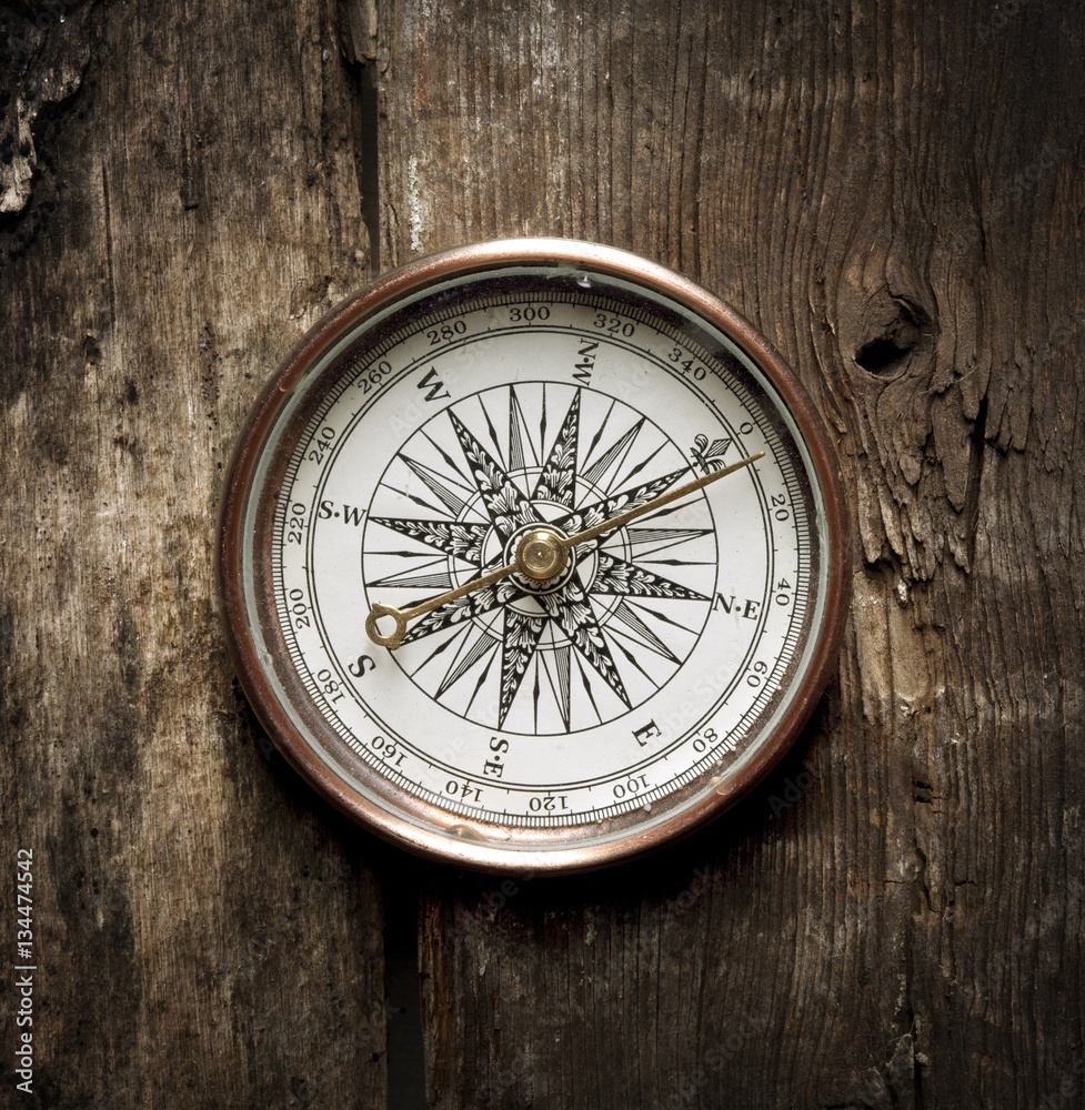 antique compass on wooden background