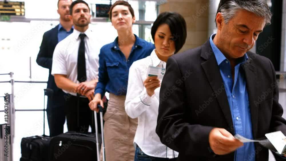 Commuters standing in queue for check-in at airport