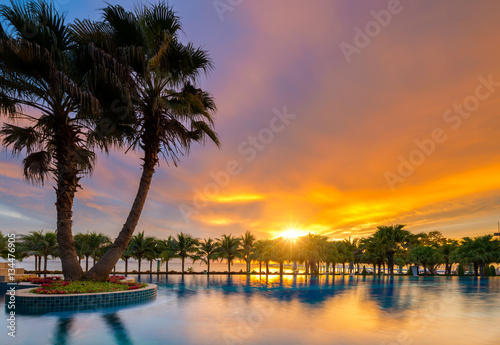 Beautiful sunset over the sea with a view at palms on the white beach © Getty Gallery