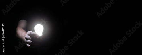 man in dark with glow bulb photo