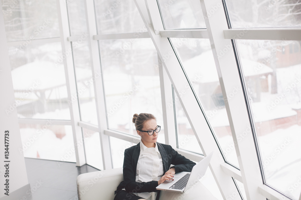 Young business woman using laptop in office. Young business woman using laptop in office.