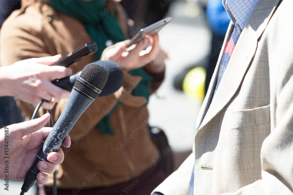 Journalist holding a microphone conducting an TV or radio interview Journalist holding a microphone conducting an TV or radio interview