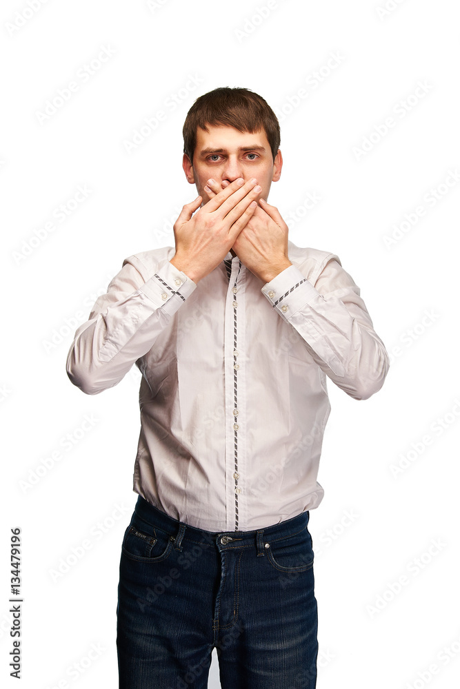Very strict and handsome man will not say anything. Young serious guy keeps a secret. Boy shows gesture secrets. Professional man model posing for a photograph in the studio on a white background. Very strict and handsome man will not say anything. Young serious guy keeps a secret. Boy shows gesture secrets. Professional man model posing for a photograph in the studio on a white background.