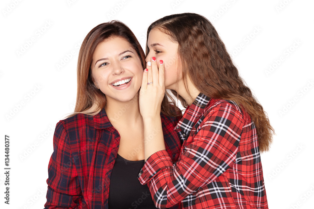 Young attractive girl whispering in the ear of his sister Young attractive girl whispering in the ear of his sister