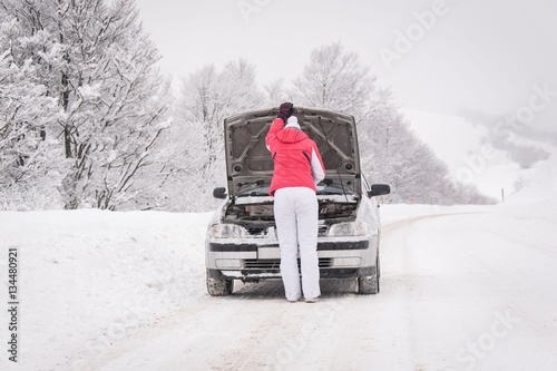 Woman with car probelm in winter mountain road photo